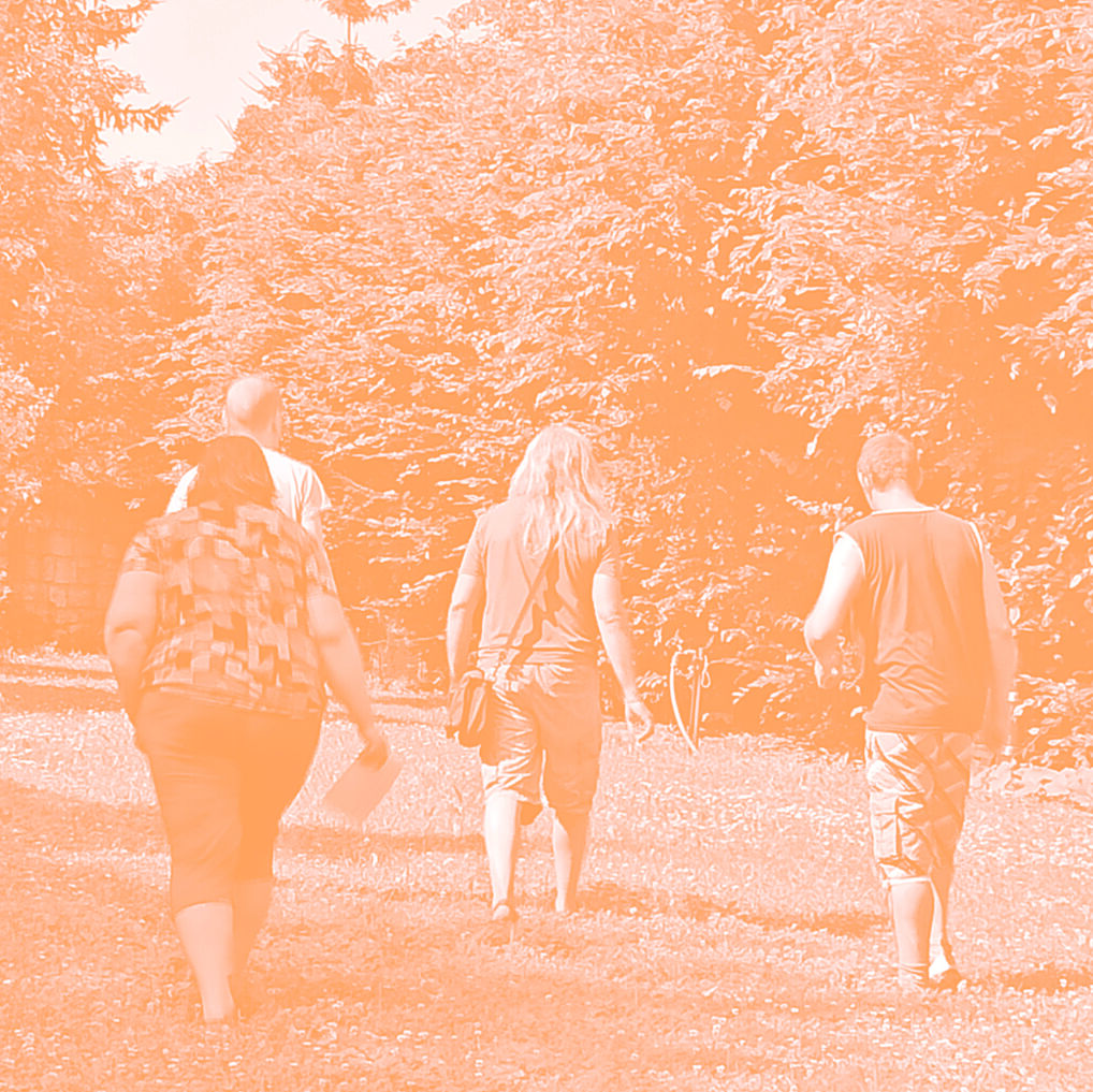 Lidé jdou po&nbsp;louce směrem k&nbsp;lesu